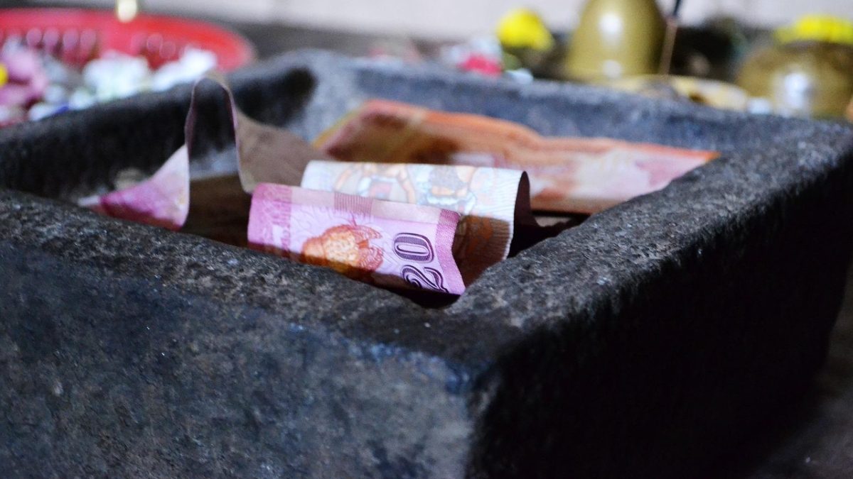 A stone container filled with banknotes symbolizing charitable donations for ai charity initiatives