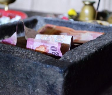 A stone container filled with banknotes symbolizing charitable donations for ai charity initiatives