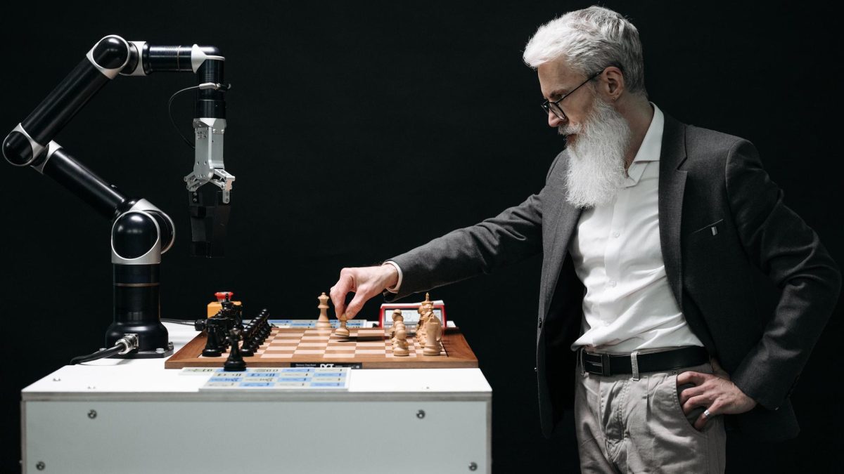 Man strategizing chess moves with a robotic arm, reflecting the interplay between human and ai agents in tech oversight discussions.
