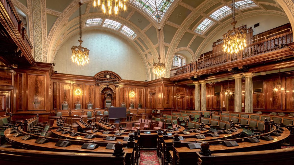Legislative chamber highlighting the need for ai laws and governance in managing technology.