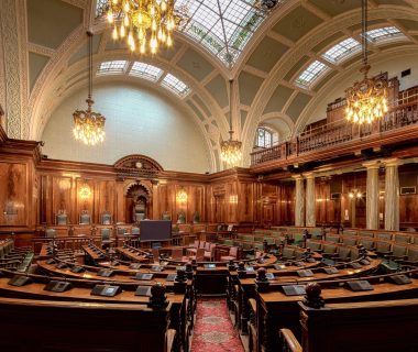 Legislative chamber highlighting the need for ai laws and governance in managing technology.