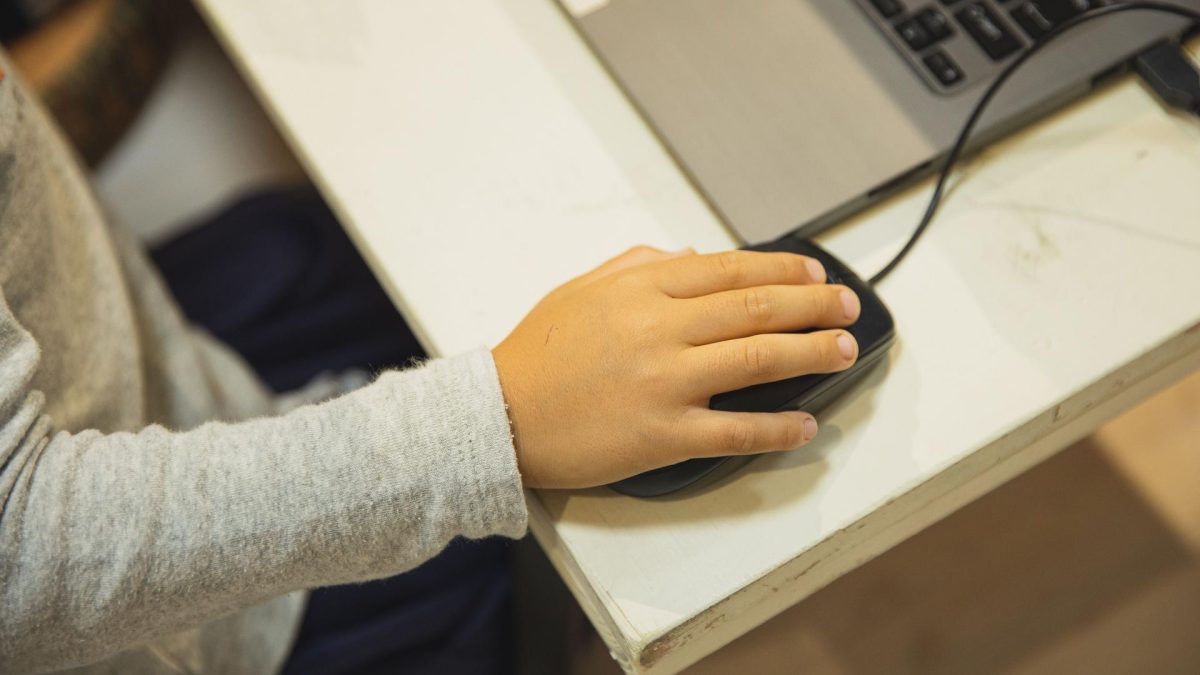 Student using a laptop while discussing implications of ai laws in age verification