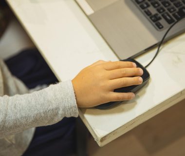 Student using a laptop while discussing implications of ai laws in age verification