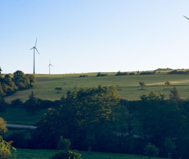 Wind turbines symbolize sustainable infrastructure essential for AI's long-term development, reflecting trends in AI news.