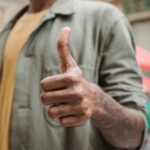 Thumbs-up gesture symbolizing a consumer's willingness to recommend a brand after AI ad disclosure