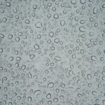 Water droplets on glass symbolize transparency in AI advertising and consumer trust.